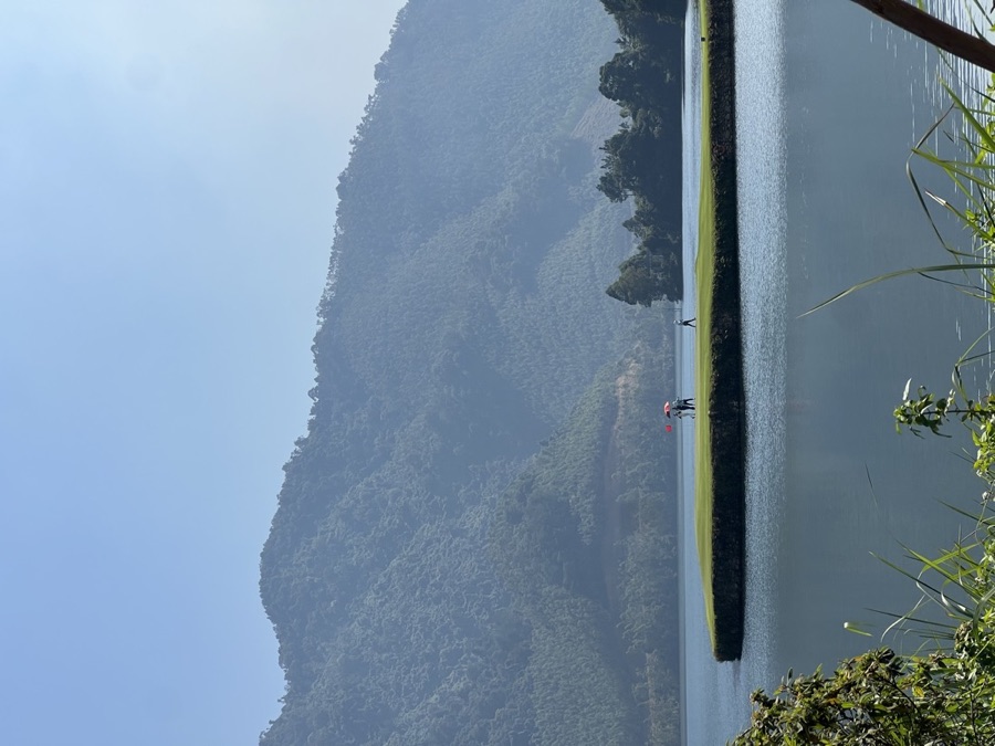 A small boat on a river winding between limestone karsts