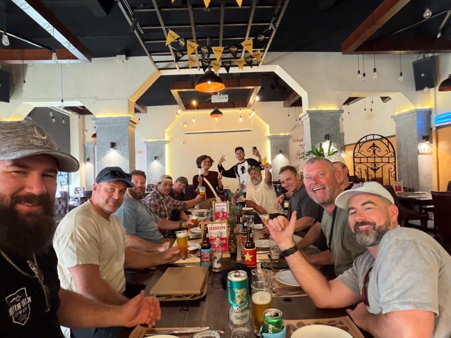A long dinner table of friends mid-celebration